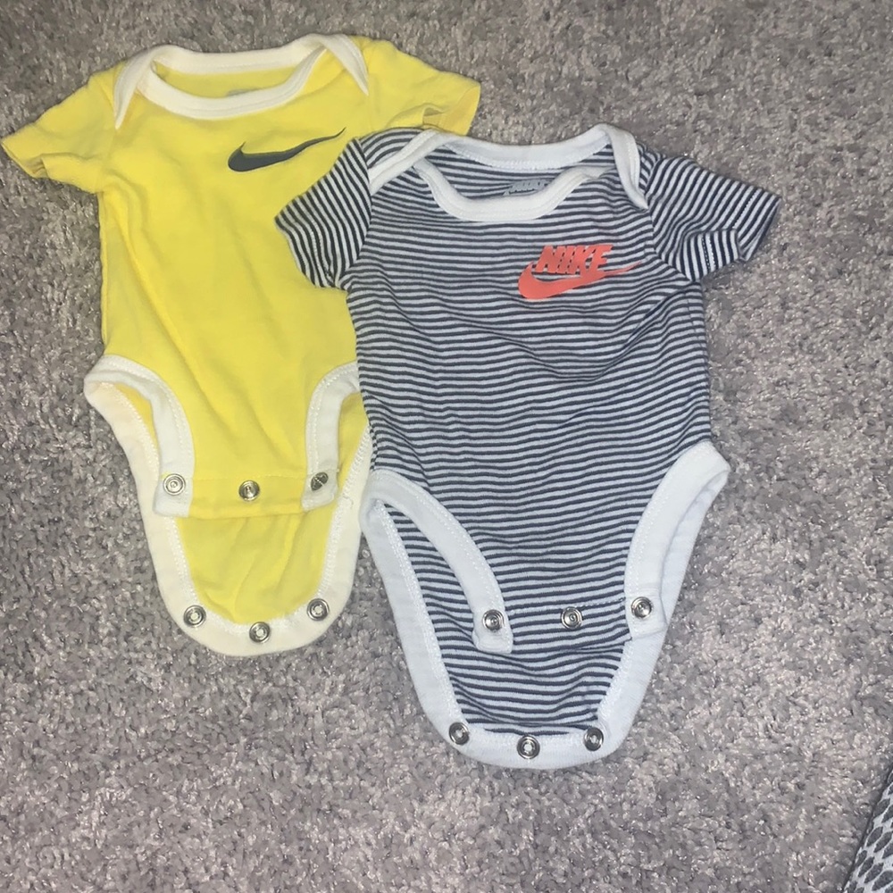 Yellow Nike onesie and black and white Nike onesie
